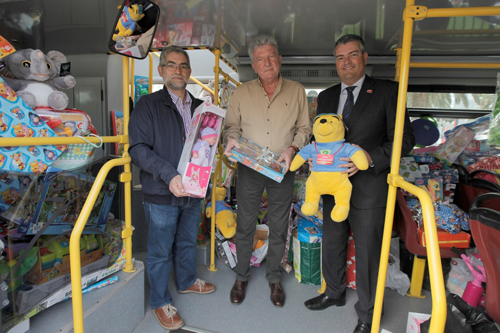 El concejal de Turismo, Pedro Quevedo; el director de operaciones de City Sightseeing en la ciudad, Antonio Benítez y el presidente de la Casa de Galicia, Albino Aneiros; en la guagua turiística junto a los juguetes