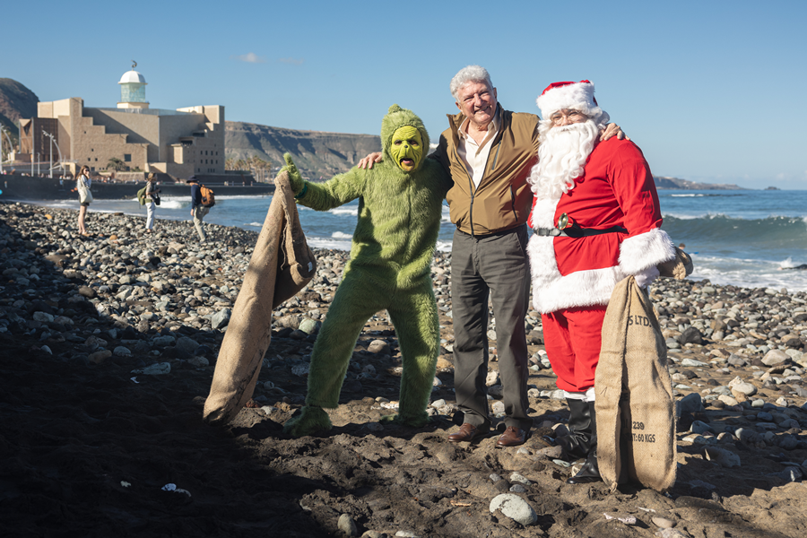 El Grinch y Papa Noel reivindican en la playa de Las Canteras una Navidad más verde y un océano más limpio